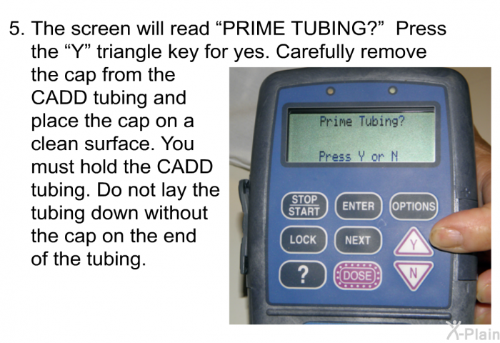 The screen will read “PRIME TUBING?” Press the “Y” triangle key for yes. Carefully remove the cap from the CADD tubing and place the cap on a clean surface. You must hold the CADD tubing. Do not lay the tubing down without the cap on the end of the tubing.