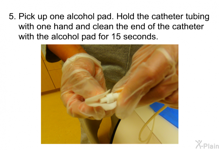 Pick up one alcohol pad. Hold the catheter tubing with one hand and clean the end of the catheter with the alcohol pad for 15 seconds.