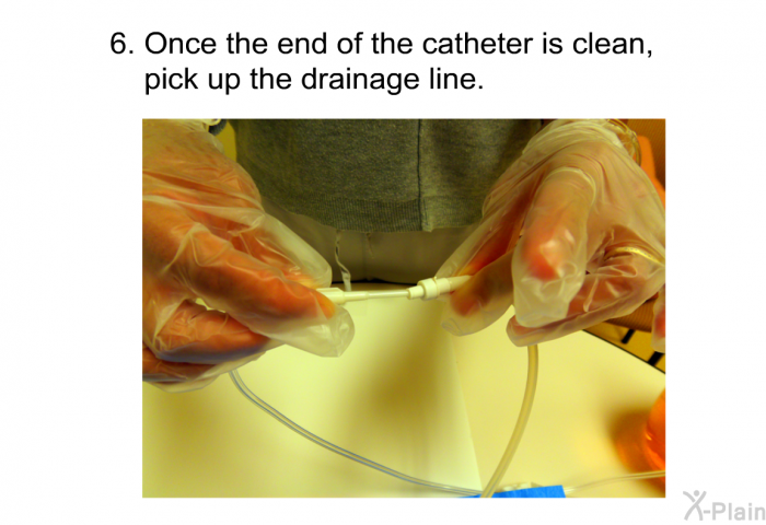 Once the end of the catheter is clean, pick up the drainage line.